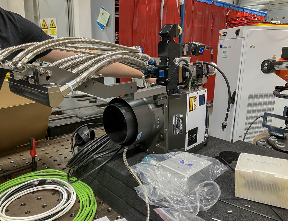 Fiber laser cutting head during sheet metal cutting — close-up